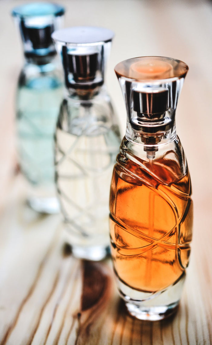 Three glass perfume bottles representing different fragrance families