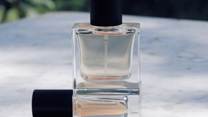 Clear glass fragrance bottle on a white table