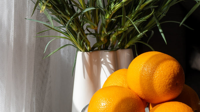 Flowers and oranges on a sunlit table